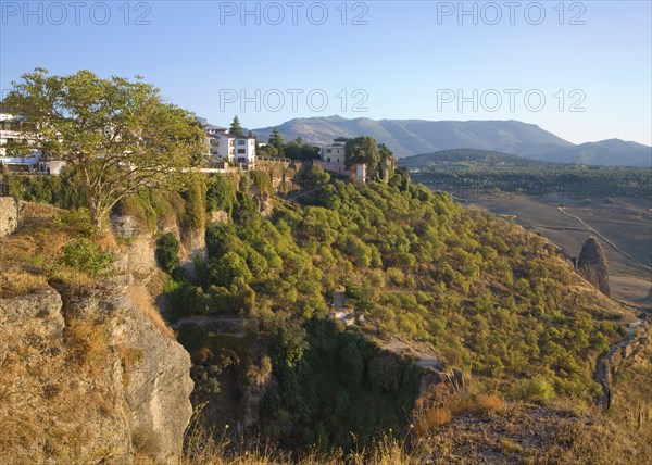 Historic buildings perched on sheer cliff top in Ronda, Spain, Europe