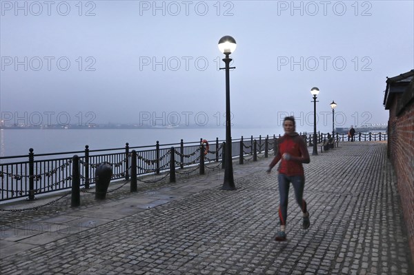 A woman jogs in the morning near the Royal Albert Dock, Liverpool, 01/03/2019