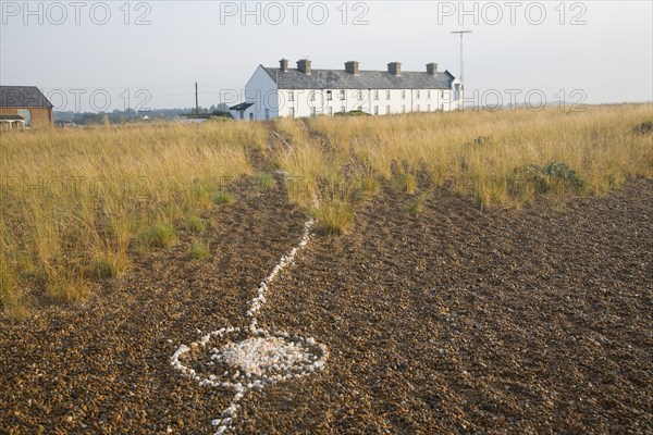 Line of white shells crossing beach to houses at the coastal hamlet of Shingle Street, North Sea coast, Suffolk, England, UK