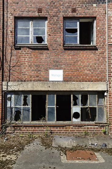 Empty dilapidated factory building, broken window panes, sign saying assembly, industrial ruin, brick, facade detail, lost place, Germany, Europe