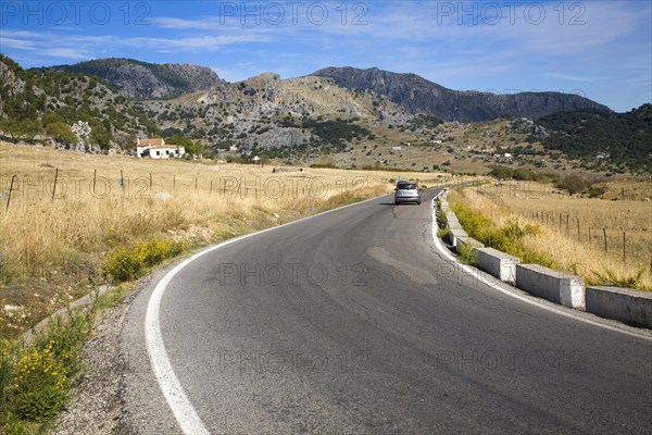 Vehicle driving around corner in rural road in Sierra de Grazalema natural park, Cadiz province, Spain, Europe