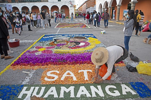 Peruvian woman making a floor painting in the Plaza de Armas, spectators watching, Ayacucho, Huamanga province, Peru, South America