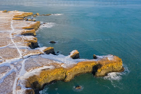 Aerial view over volcanic basalt cliff near Arnarstapi on the southern side of the Snaefellsnes Peninsula in winter, Western Region, Iceland, Europe