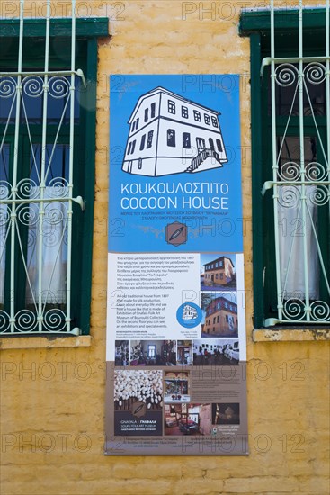 Informative plaque on a yellow wall advertising a cultural centre or museum, sign at Koukoulospito, house with traditional architecture built for rearing silkworms, museum, Soufli, Eastern Macedonia and Thrace, Greece, Europe