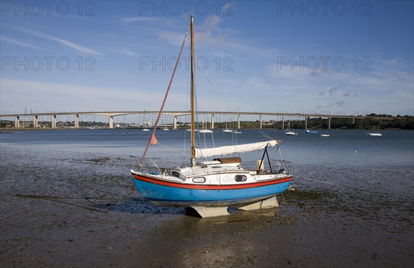 Sailing boat in mud at low tide with the Orwell Bridge in the background, River Orwell estuary, Freston Point, Suffolk, England, United Kingdom, Europe