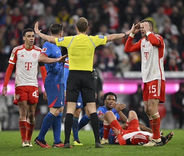 Controversial decision by referee Sascha Stegemann after tackle, action Lois Openda RasenBallsport Leipzig RBL (17) against Raphael Guerreiro FC Bayern Munich FCB (22) disbelieved, Eric Dier FC Bayern Munich FCB (15) Jamal Musiala FC Bayern Munich FCB (42) Willi Orban RasenBallsport Leipzig RBL (04) Allianz Arena, Munich, Bavaria, Germany FC Bayern Muenchen vs RasenBallsport Leipzig RBL 24.02.2024 DFL REGULATIONS PROHIBIT ANY USE OF PHOTOGRAPHS AS IMAGE SEQUENCES AND/OR QUASI-VIDEO