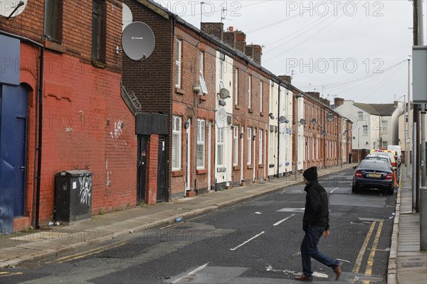 A man walks across a street near Liverpool FC's football stadium, 02/03/2019