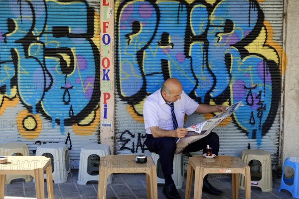 Reading newspaper, bazaar district, Eminoenue, Istanbul, European part, Istanbul province, Turkey, Asia