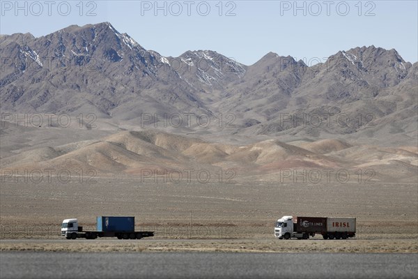 Truck on a motorway in the central desert of Iran, snow-capped mountains can be seen in the background, 13.03.2019