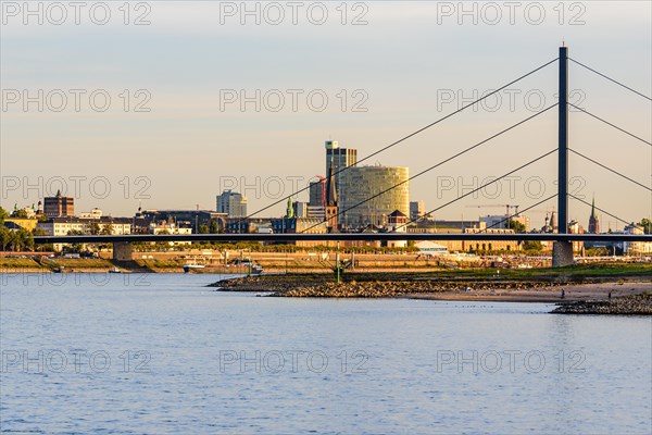 City scene with bridge and buildings on the riverbank under a clear sky shortly in front of sunset, Theodor-Heuss-Bruecke, Duesseldorf, North Rhine-Westphalia