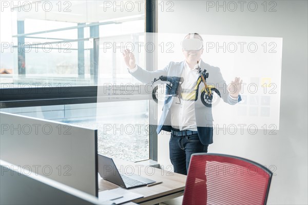 Businessman with augmented reality goggles touching interactive screen with a motorbike on it