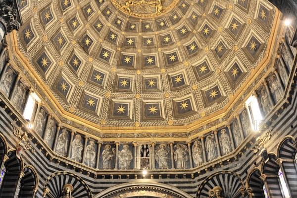 The dome of the cathedral with starry sky and black and white striped marble columns and round arches, Siena, Tuscany, Italy, Europe