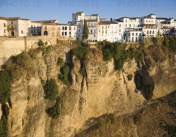 Historic buildings perched on sheer cliff top in Ronda, Spain, Europe