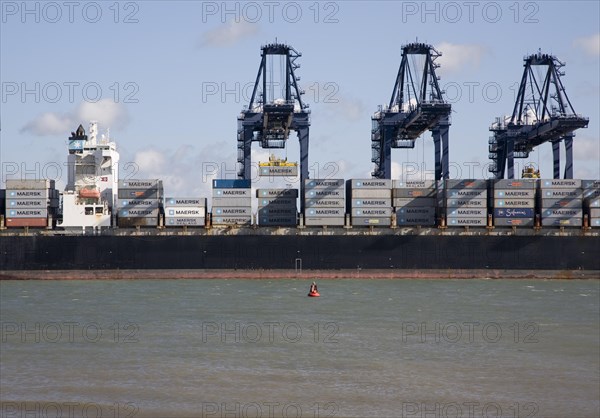 Cranes and container ships at Trimley Docks part of the Port of Felixstowe, Britain's busiest container port, from Shotley, Suffolk, England, United Kingdom, Europe