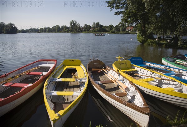 Colourful rowing boats on the Meare boating pond lake at Thorpeness, Suffolk, England, UK