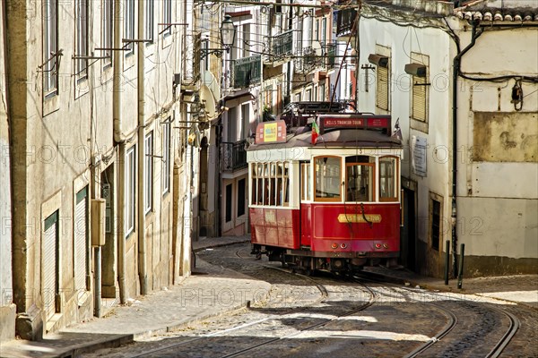 The historic red tram winds its way through Lisbon's historic centre past the old houses of this beautiful city