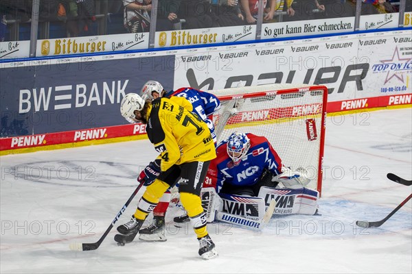 23.02.2024, DEL, German Ice Hockey League, 48th matchday) : Adler Mannheim (yellow jerseys) against Nuremberg Ice Tigers (blue jerseys) . Dangerous situation in front of the Nuremberg Ice Tigers goal. Ryan MacInnis (74, Adler Mannheim) and Daniel Schmoelz (25, Nuernberg Ice Tigers) fighting for the puck