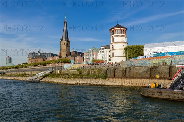 Sunny day on the Rhine promenade with church tower and buildings in the background, Duesseldorf, North Rhine-Westphalia