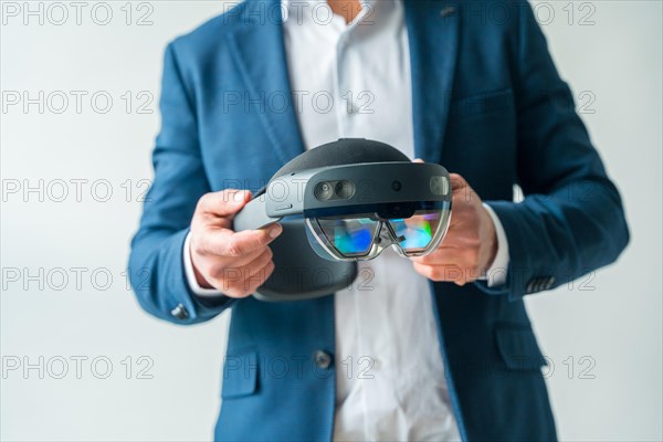 Studio photo with close-up of a mixed reality goggles in hands of a businessman