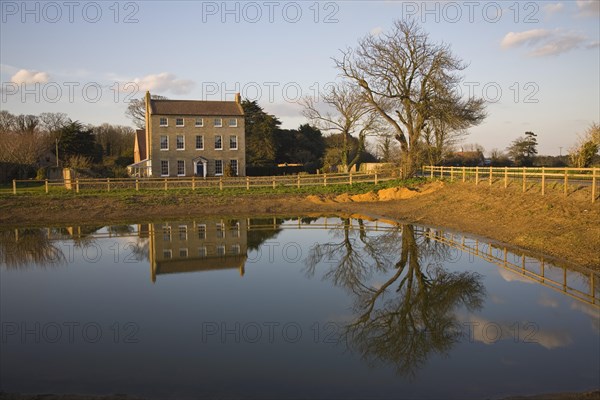 High House Farm farmhouse reflected in water of newly dug pond, Bawdsey, Suffolk, England, United Kingdom, Europe