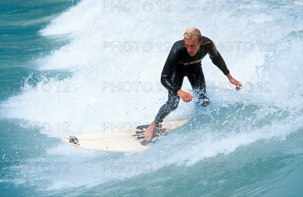 Young man surfing on river Isar during floods, Wittelsbacherbruecke, Munich, Bavaria, Germany, vintage, retro, Europe