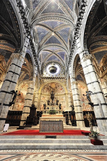 Altar area, The central nave of the cathedral with its black and white striped marble columns, cross and round arches, Siena, Tuscany, Italy, Europe
