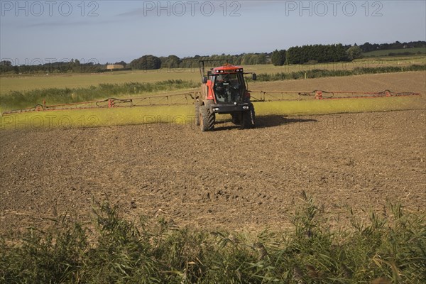 Farm machinery spraying Glyphosate herbicide on an arable field near Hollesley, Suffolk, England, United Kingdom, Europe