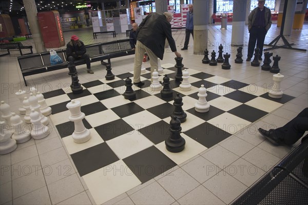 Men playing chess on a giant set in the public library, Rotterdam, South Holland, Netherlands