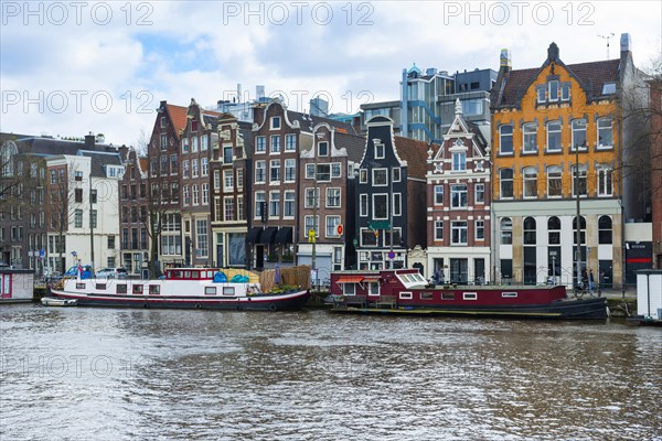 Typical row of houses with canal houses on the Amstel canal, centre, urban, facade, history, city history, historical, architectural style, building, city centre, metropolis, city trip, European, water, sightseeing, tourism, travel, holiday, architecture, Amsterdam, Netherlands