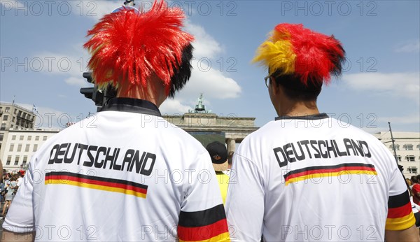 Football fans wear wigs with the colours of the German flag for the World Cup opening match between Germany and Mexico in the fan mile at the Brandenburg Gate in Berlin, 17.06.2018