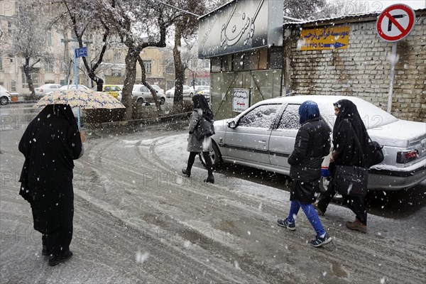 Heavy snowfall in Arak, Iran, woman with chador and umbrella and traditional clothing, 16/03/2019, Asia