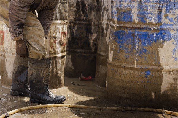 Plastic bag to protect feet on a construction site in Nigeria, 06/02/2024