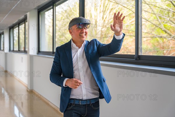Happy casual mature businessman using Virtual reality simulator in the corridor of a building