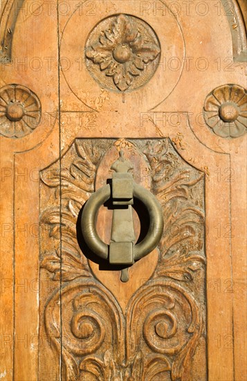 Ornate decorated wooden door with brass knocker in the old city, Ronda, Spain, Europe