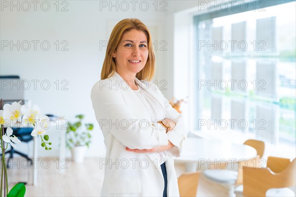 Elegant female estate agent posing proud standing in the office