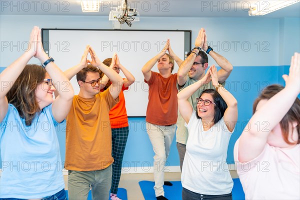 Happy disabled people having fun during yoga class together in a gym