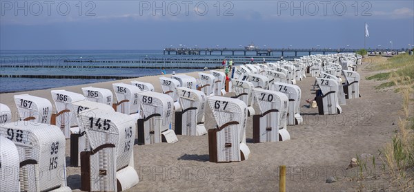 White beach chairs on the beach, behind the pier in Kuehlungsborn, Mecklenburg-Vorpommern, Germany, Europe