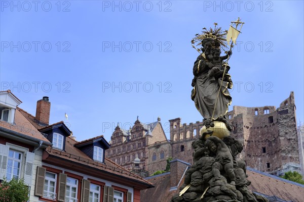 Statue with crown and sceptre, Marienbrunnen, in front of a castle ruin and blue sky, Heidelberg, Baden-Wuerttemberg, Germany, Europe