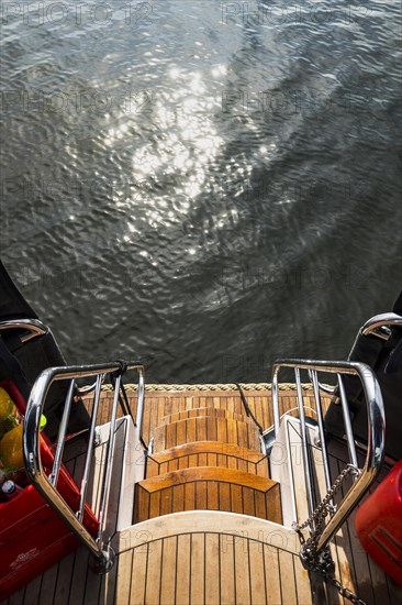 Bathing ladder as an exit at the stern of a houseboat, houseboat, holiday, journey, sun, reflection, water, bathing, swimming, idyllic, lake. Exit, ladder, stairs, railing, ship, stern of a ship, yacht, sailboat, motorboat, boat trip, excursion, boat trip, mood, atmosphere, seafaring, water sports