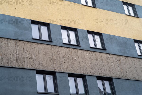 Rows of windows on a yellow-grey building facade, urban environment
