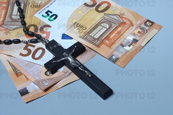 Crucifix and banknotes, church and money, church tax