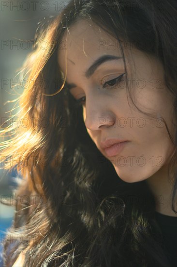 A contemplative woman bathed in soft natural light, exuding a gentle mood, a complete tool panel in background with bokeh effect, traditional male jobs by Mixed-race latino woman