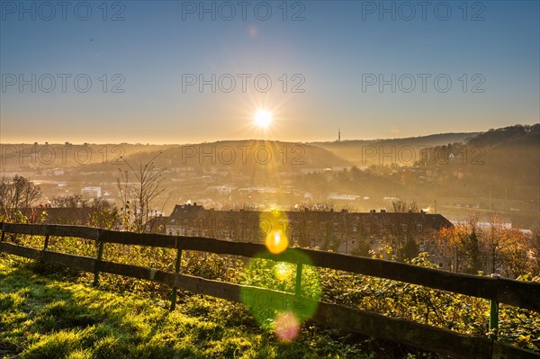 Early morning with sunrise behind a fence separating a field from houses, Arrenberg, Elberfeld, Wuppertal, Bergisches Land, North Rhine-Westphalia