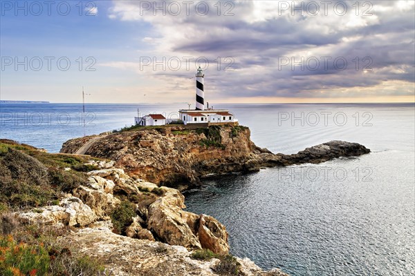 Lighthouse on a cliff with a scenic sea backdrop during sunset, Coastal Hiking tour in the south of Mallorca