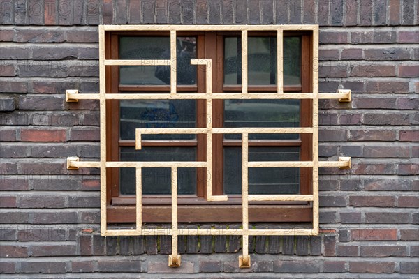 Lattice wooden window in Art Nouveau style, embedded in a brick wall