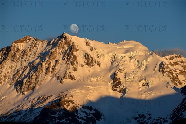 The snow-covered summit of Cerro Hermoso at sunrise with the moon, Perito Moreno National Park, Patagonia, Argentina, South America