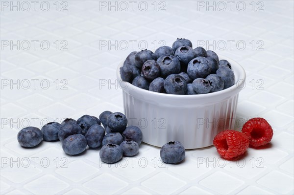 Blueberries in small bowls, raspberries