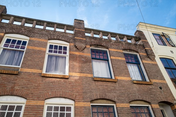 Facade of a brick house with decorative bricks and several windows