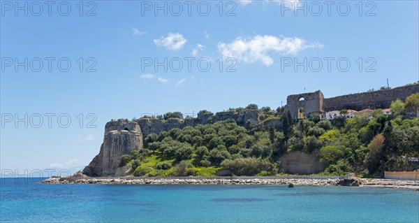 View of a sunny coastal landscape with blue sea, historic ruins and lush vegetation, Byzantine fortress, Koroni, Pylos-Nestor, Messinia, Peloponnese, Greece, Europe