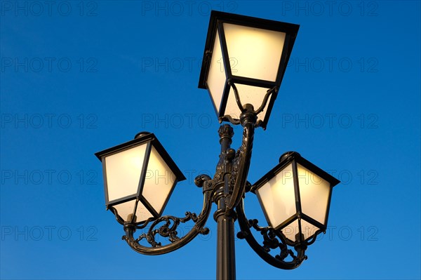 Luminous street lamp in front of a blue sky, vintage, Roermond, Netherlands